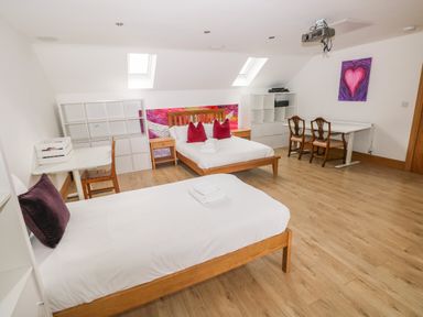 A bedroom with two beds and a desk at Ty-Gan Dderwen in Llangennech, Llanelli