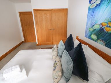A bedroom with a bed and artwork at Ty-Gan Dderwen, Llangennech, Llanelli