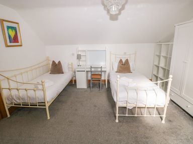 A bedroom with two beds and a desk at Ty-Gan Dderwen in Llangennech, Llanelli