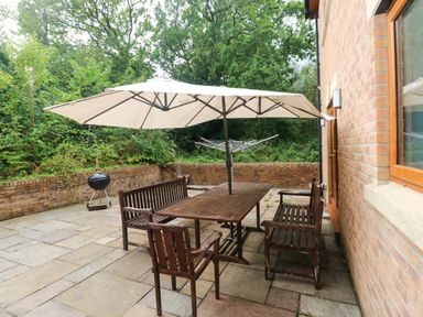 An outdoor patio with a table and chairs at Ty-Gan Dderwen in Llangennech, Llanelli