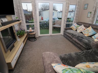 A living room with a sofa and coffee table at Offspray Court 1 Scratby