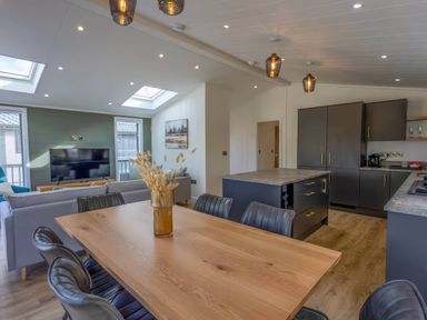A dining room with a wooden table and chairs at Isca Lodge - With Decking - Lodge 1 Wombleton