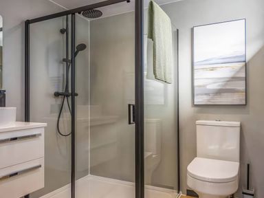 A bathroom featuring a shower, toilet, sink, and wall art at Isca Lodge - With Decking - Lodge 1, Wombleton