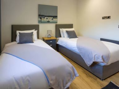 A bedroom with two beds and a nightstand at Isca Lodge - With Decking - Lodge 1 in Wombleton