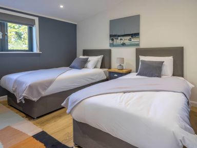 A bedroom with two beds and a nightstand at Isca Lodge in Wombleton