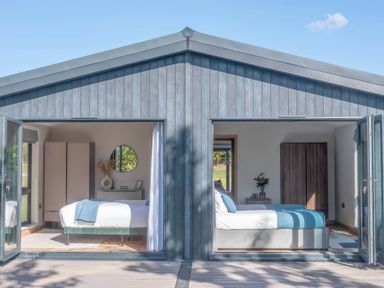 A bedroom with two beds and wardrobes at Isca Lodge in Wombleton