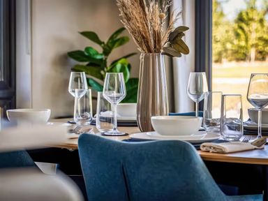 A dining room table set with plates and glasses at Rye Lodge in Wombleton