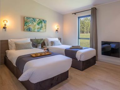 A bedroom with two beds and a window at Rye Lodge in Wombleton