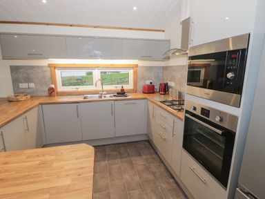A kitchen with a sink and oven at Oak Lodge in Admaston near Abbots Bromley
