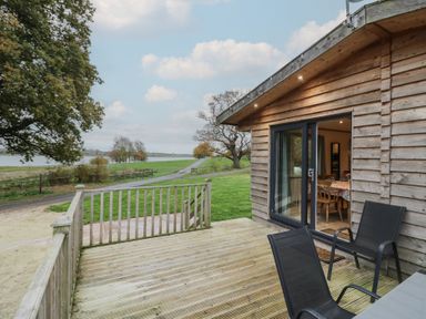 An outdoor seating area with a table and chairs at Oak Lodge Admaston near Abbots Bromley