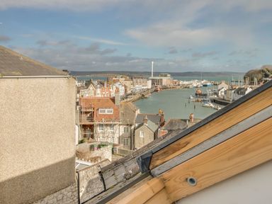 View of the harbor with buildings and water at Seahorse Cottage in Weymouth