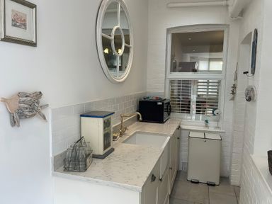 A kitchen with a sink and microwave at Seahorse Cottage in Weymouth
