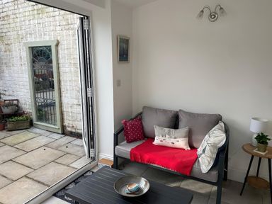 A snug with a sofa and a table at Seahorse Cottage in Weymouth