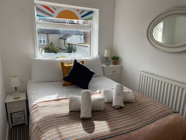 A bedroom with a bed and bedside table at Seahorse Cottage in Weymouth