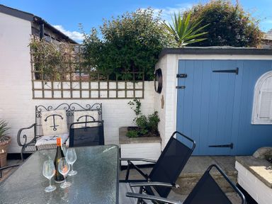 A garden with table and chairs at Seahorse Cottage in Weymouth