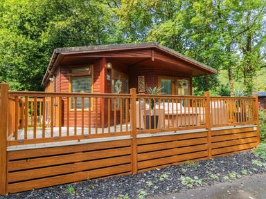 A cabin with a deck and outdoor furniture at Terabitha Lodge Troutbeck