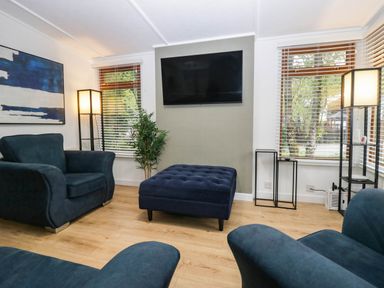 A living room with a sofa and ottoman at Terabitha Lodge in Troutbeck