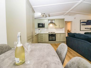 A kitchen with a table and champagne at Terabitha Lodge in Troutbeck
