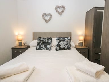 A bedroom with a bed and bedside lamps at Terabitha Lodge in Troutbeck