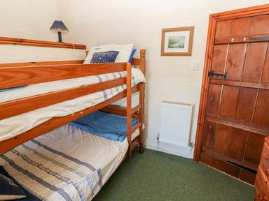A bedroom with a bunk bed and radiator at Ty Fferm in Newport