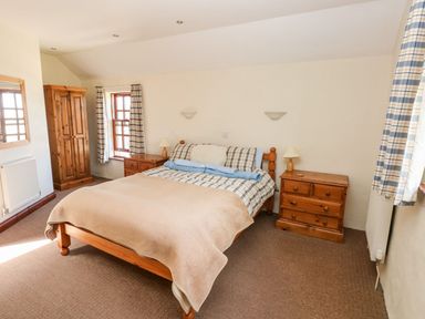 A bedroom with a bed and wardrobe at Ty Fferm in Newport
