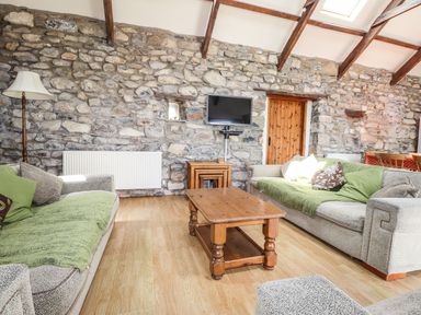 A living room with sofas and a wooden table at Ty Felin in Newport