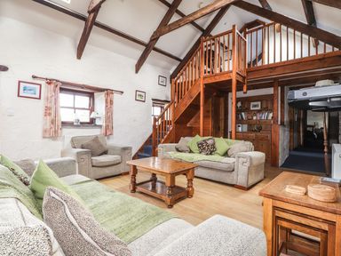 A living room with sofas and a staircase at Ty Felin Newport