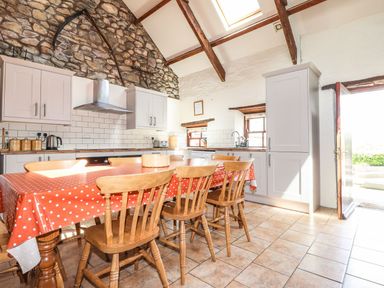 A kitchen with a wooden table and chairs at Ty Felin, Newport