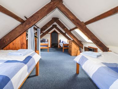 A bedroom with multiple beds and a dresser at Ty Felin Newport