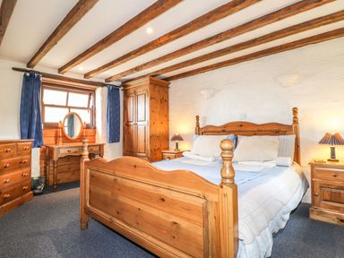 A bedroom with wooden furniture and a window at Ty Felin Newport