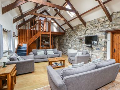 A living room with grey sofas and a wooden coffee table at Ty Felin in Newport, Pembrokeshire