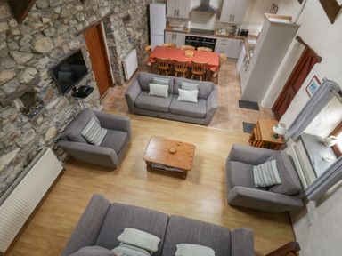 A living room with seating and kitchen in Ty Felin Newport, Pembrokeshire