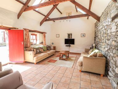 A living room with a television and seating area at Ty Gwartheg Newport