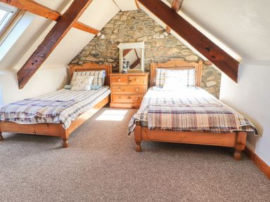 A bedroom with twin beds and a wooden dresser at Ty Gwartheg Newport