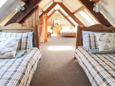 A bedroom with two beds and a chest of drawers at Ty Gwartheg Newport