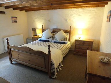 A bedroom with a bed and wooden furniture at Ty Cariad in Newport