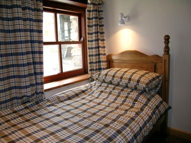 A bedroom with a bed and window at Ty Cariad Newport