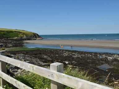 A beach with water and people at Ty Cariad in Newport