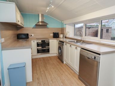 A kitchen with appliances including a washing machine and oven at Braeburn in Bamburgh