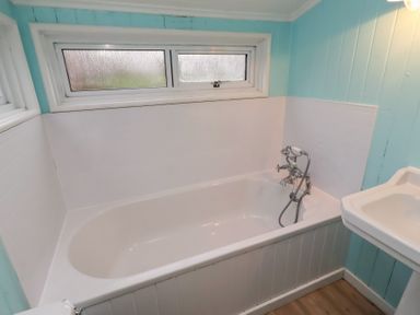 A bathroom with a bathtub and a sink at Braeburn in Bamburgh
