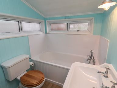 A bathroom with bathtub and washbasin at Braeburn in Bamburgh