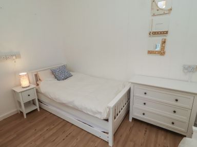 A bedroom with a bed and dresser at Braeburn in Bamburgh