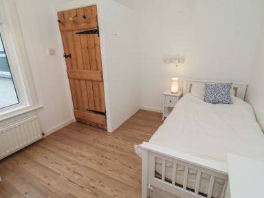 A bedroom with a single bed and a nightstand at Braeburn in Bamburgh