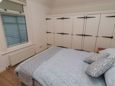 A bedroom with a bed and cupboards at Braeburn in Bamburgh
