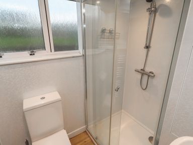 A bathroom with a shower and toilet at Braeburn in Bamburgh