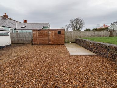A garden with a shed and gravel at Braeburn in Bamburgh