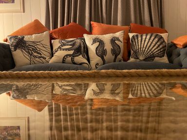 A couch with decorative pillows at Braeburn in Bamburgh