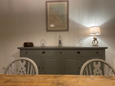 A dining room with a sideboard and lamp at Braeburn in Bamburgh