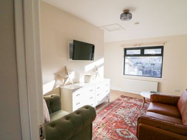 A living room with a sofa and television at Duck Cottage