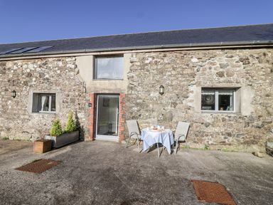 An outdoor area with a table and chairs at Dairy Cottage Bullhornstone near South Brent